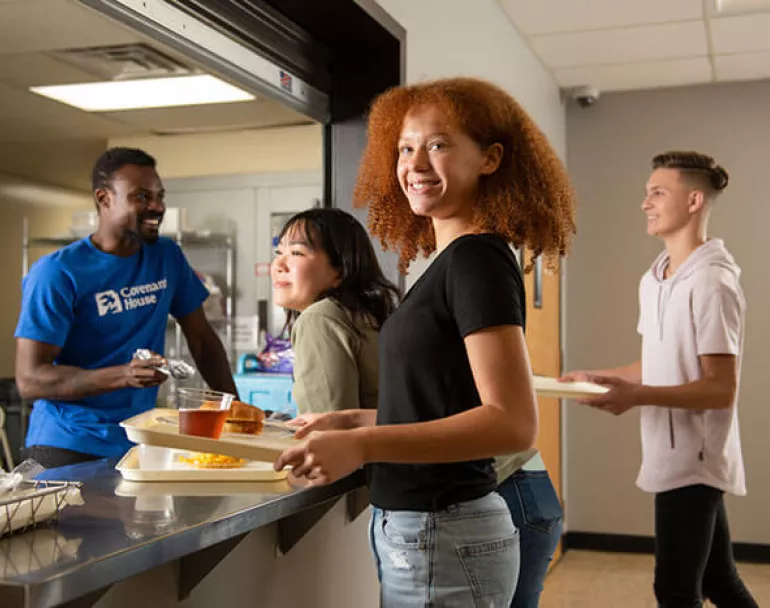 Young lady receiving food in a Covenant House Cafeteria