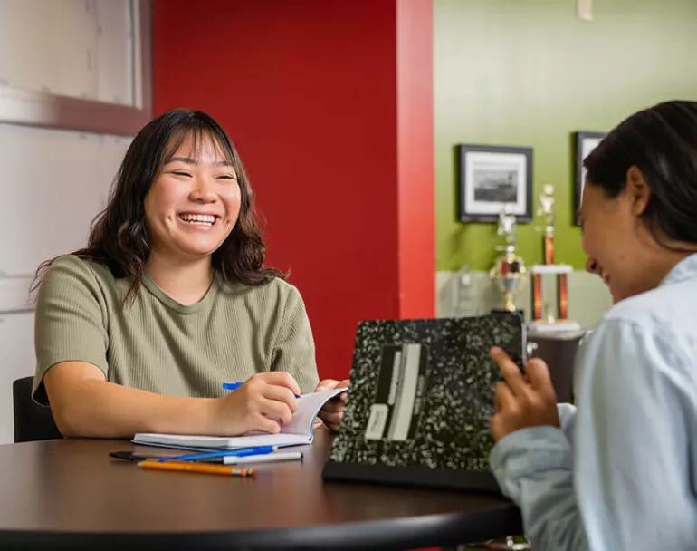 youth smiling and doing school work