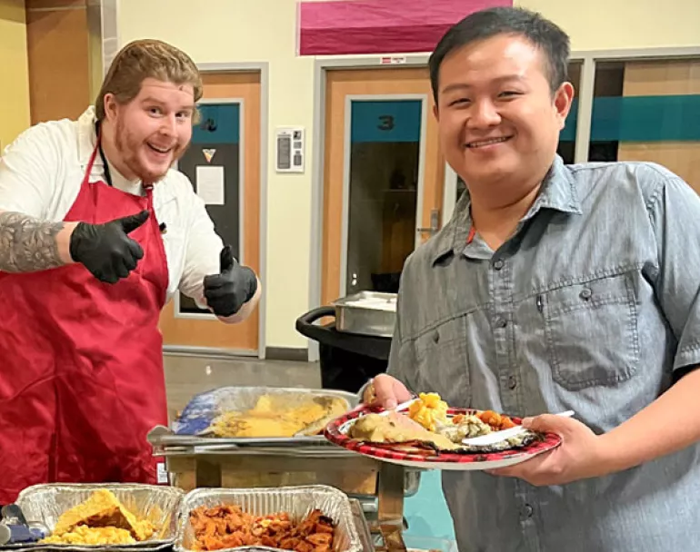 Covenant House Staff serving former homeless youth a warm meal