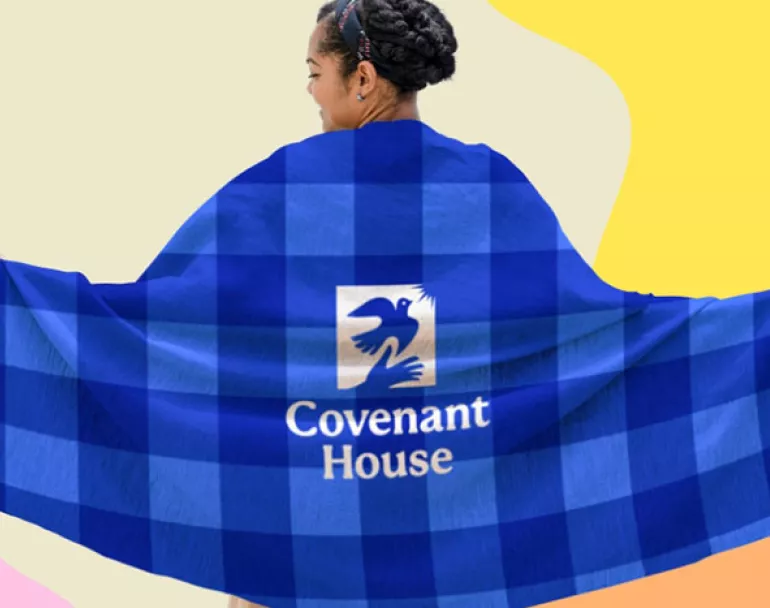 Former homeless youth wrapped in Covenant House fleece blanket