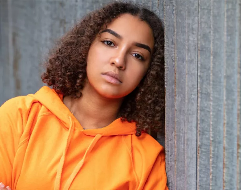 Homeless teenage girl leaning against wall | Covenant House - Donate Today