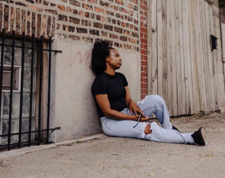 Homeless girl sitting on the ground outside | Covenant House - Donate Now