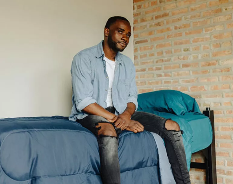 homeless youth sitting on bed | Covenant House