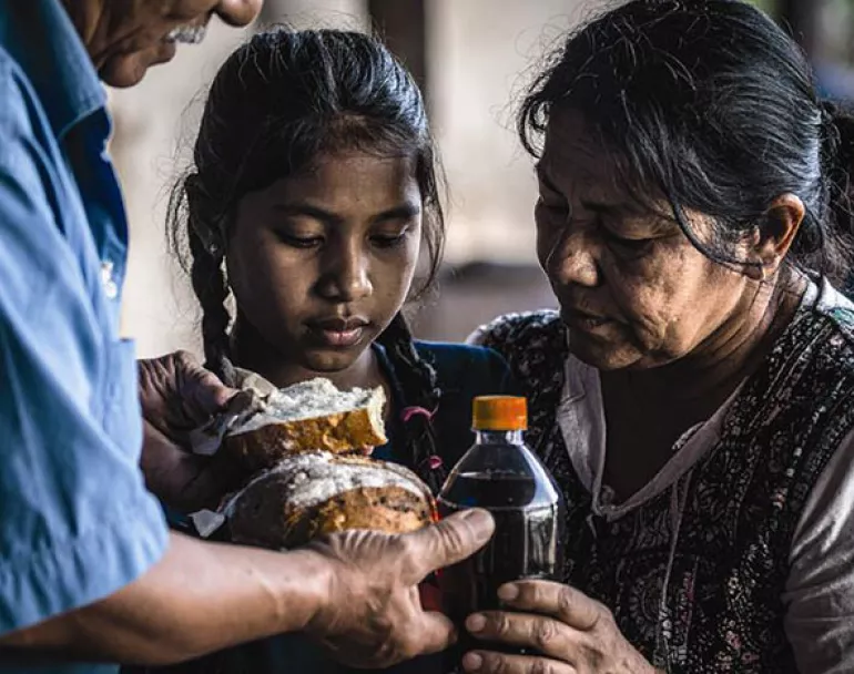 homeless Latin American girl and woman receiving food and drinks