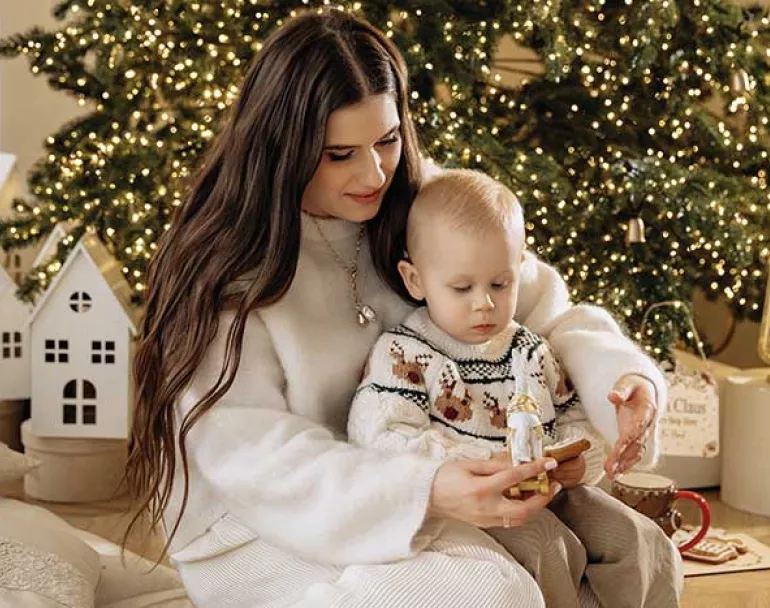 Homeless parenting youth in front of Christmas Tree | Covenant House