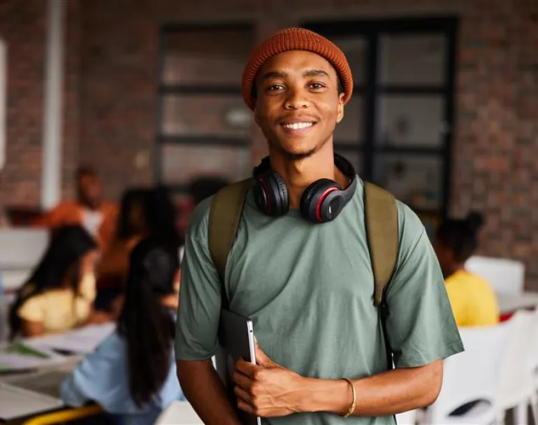 Former homeless teen smiling and wearing a backpack | Covenant House - Donate today to support homeless kids