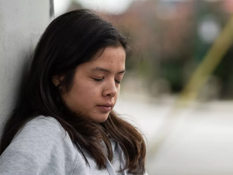 Human trafficking survivor leaning against wall | Covenant House