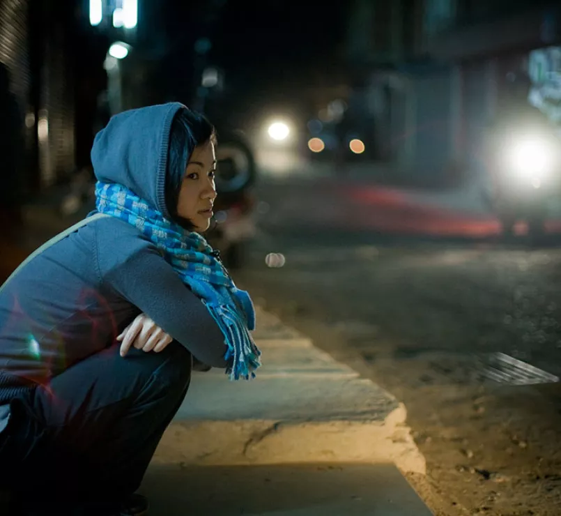 asian youth squatting on street