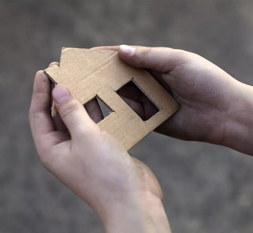 Hands carrying cardboard cut house | Covenant House - Be an Advocate