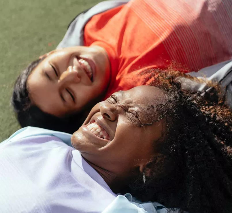 Joyful former homeless kids lying next to each other | Covenant House - Our Work